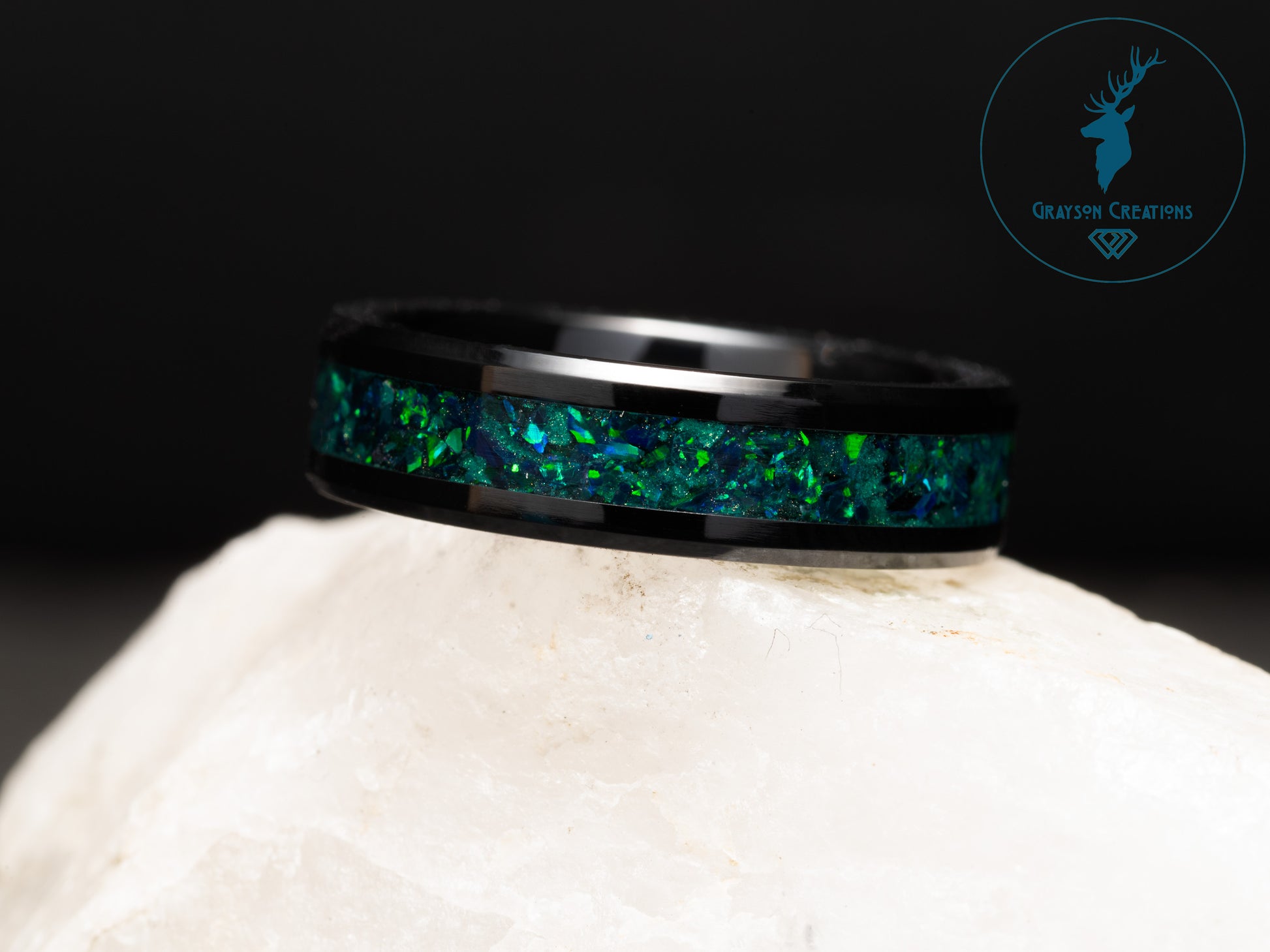 a ring with a green and blue glitter in it